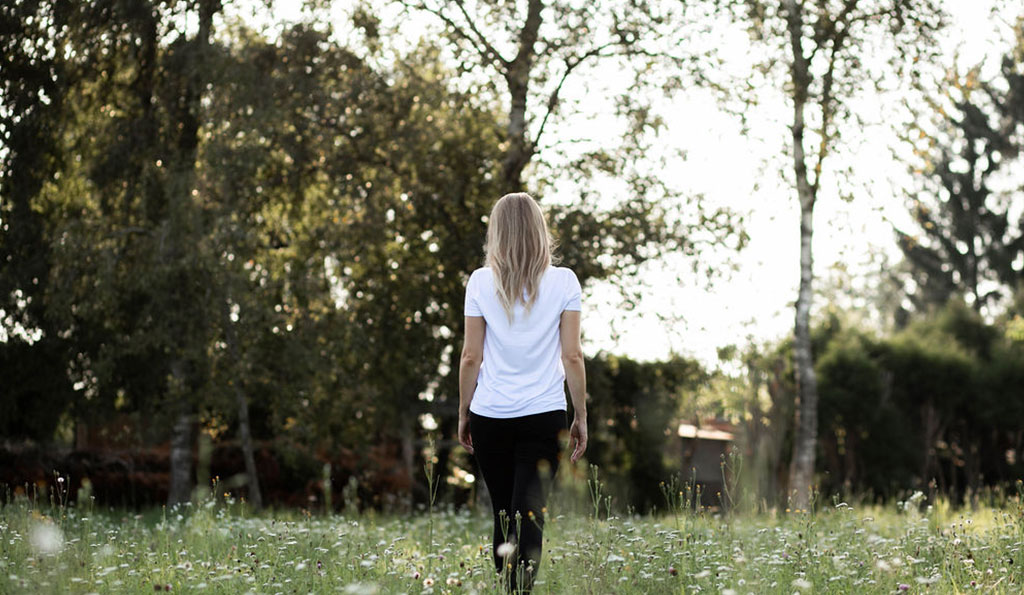 Frau mit blonden Haaren und weißem Tshirt auf Wiese