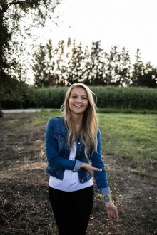 junge Gründerin mit Jeansjacke und blonden Haaren.